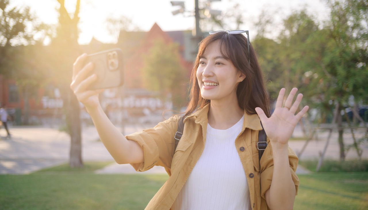 Traveler asian woman in her 30s making a livestream or selfie with a smartphone