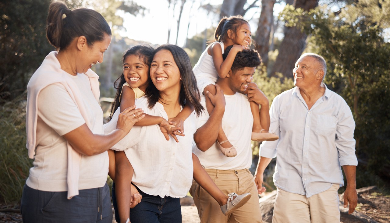 A picture of a multi-generation family in a wooded area