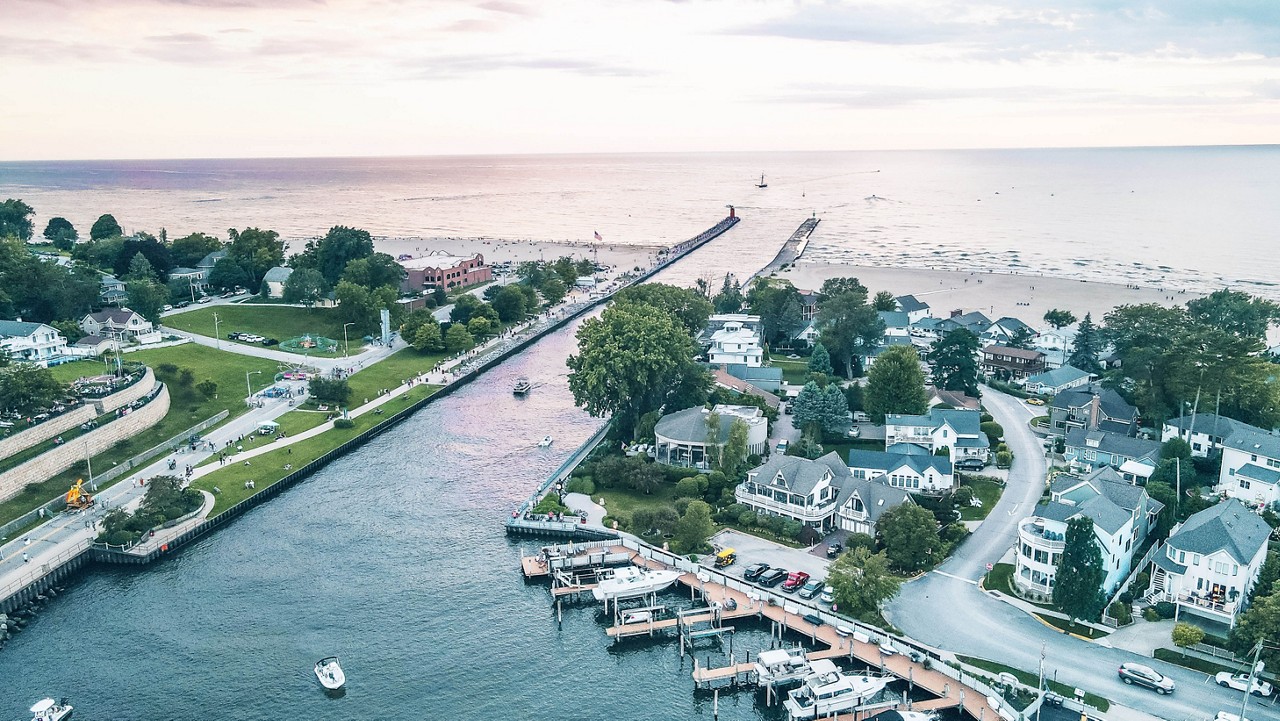 Aerial view of South Haven, Michigan, showcasing the harbor, the Black River, and the scenic beach along the shores of Lake Michigan at sunset.